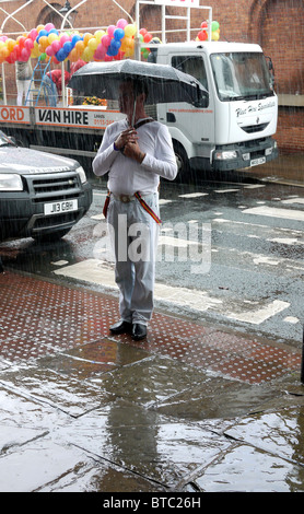 Gay uomo in piedi sotto la pioggia prima di Manchester Pride Parade 2010 REGNO UNITO Foto Stock