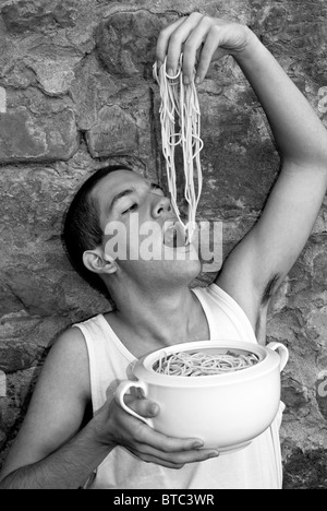 Ragazzo giovane mangiare spaghetti, Italia, M.R. Foto Stock