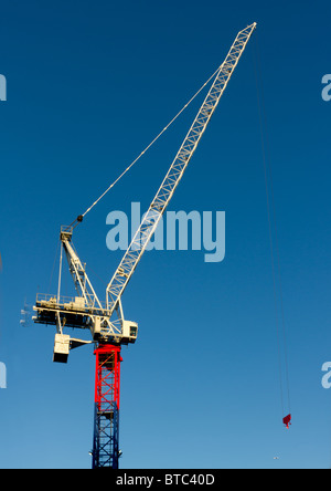 Giallo rosso e blu gru contro il cielo blu chiaro, verticale Foto Stock