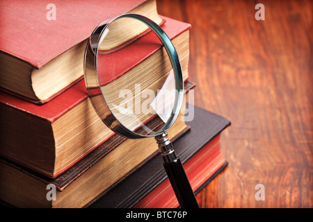 Lente di ingrandimento con libri antichi Foto Stock