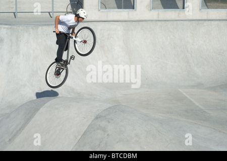 La gioventù facendo trucchi al Parco Skateboard Foto Stock