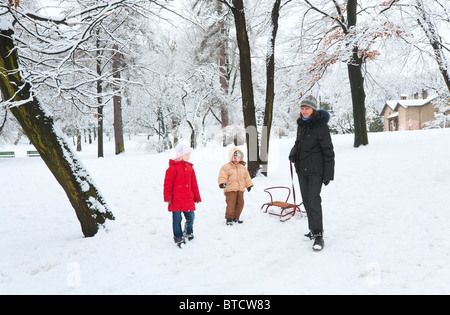 La famiglia felice (madre con il piccolo ragazzo e ragazza) in inverno il parco della città Foto Stock