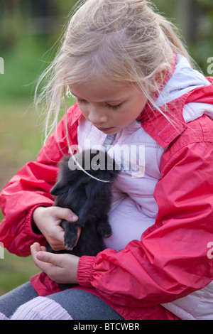 Ritratto di una bambina accarezzare un coniglio Foto Stock