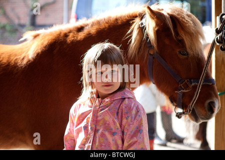 Ritratto di una bambina in piedi accanto a un pony Foto Stock