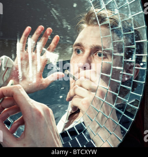 La riflessione di un uomo di inalazione di polvere di cocaina su uno specchio Foto Stock