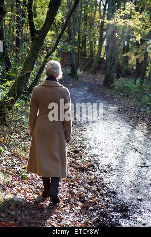 Vista posteriore di una donna passeggiate all'aperto Foto Stock