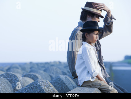 Padre e figlio seduti sul molo Foto Stock