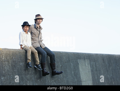 Padre e figlio seduti sul molo Foto Stock