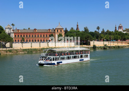 La barca turistica sul fiume Guadalquivir cruising pas il Palazzo di San Telmo a Siviglia, Spagna Foto Stock