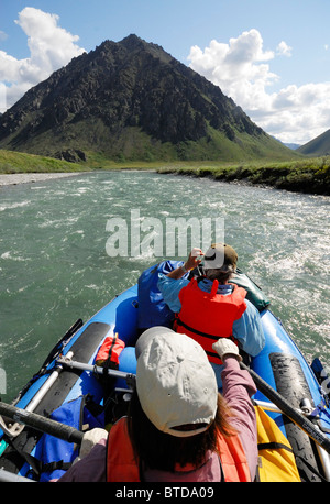 Due puntoni canottaggio attraverso il Fiume Kongakut in una giornata di sole con montagne panoramiche in background, ANWR, Alaska Foto Stock