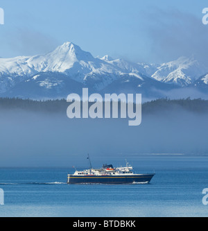 Alaska Marine Highway crociere in traghetto attraverso la nebbia, all'interno di passaggio con picchi snowcovered in background, Alaska composite Foto Stock