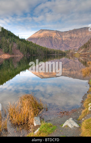 Vista sulle montagne di riflesso in Jerome lago vicino l'unione di Seward e Sterling Autostrade, Penisola di Kenai, Alaska Foto Stock