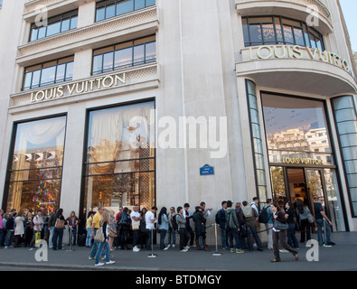 Coda di acquirenti al di fuori del negozio Louis Vuitton sugli Champs Elysees di Parigi Francia Foto Stock