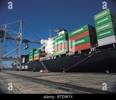 Un enorme nave container essendo caricati al porto Foto Stock