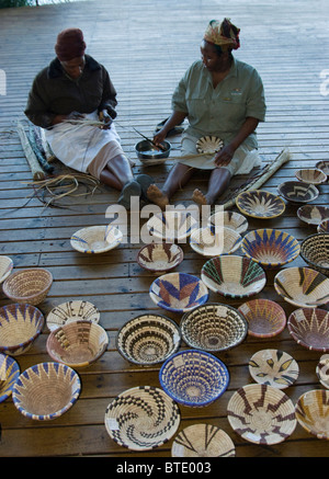 Le donne di tessitura Motswana tradizionali bocce di erba per la vendita al commercio turistico Foto Stock