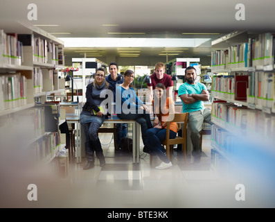 Un gruppo di studenti del college guardando la fotocamera in libreria. Sagoma orizzontale, vista frontale a piena lunghezza e spazio di copia Foto Stock