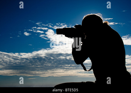 Fotografo silhouette contro il cielo blu Foto Stock