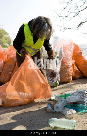 La donna la raccolta di bottiglie di plastica da riciclare Foto Stock