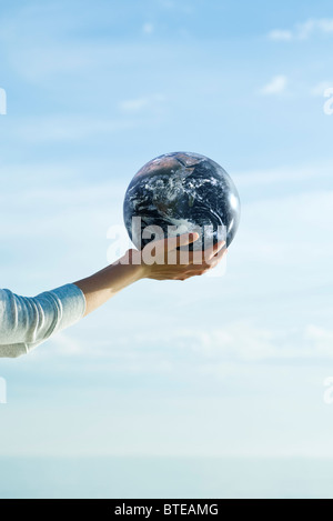 Tenendo palla fitness in mani a tazza Foto Stock