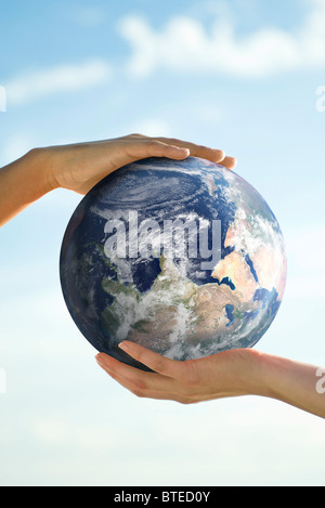 Due persone con le mani in mano il supporto di una sfera Foto Stock