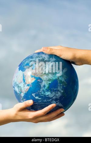 Due persone con le mani in mano il supporto di una sfera Foto Stock