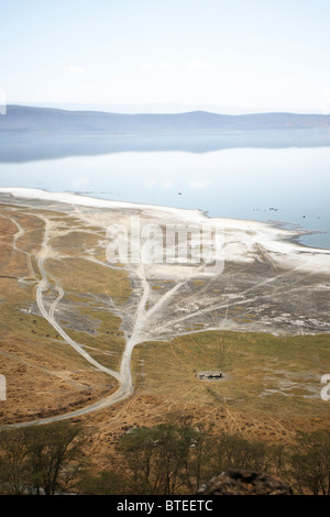 Vista aerea di una sponda del lago Nakuru con veicolo le vie di safari di veicoli e una mandria di zebra di bere da una piccola pentola Foto Stock