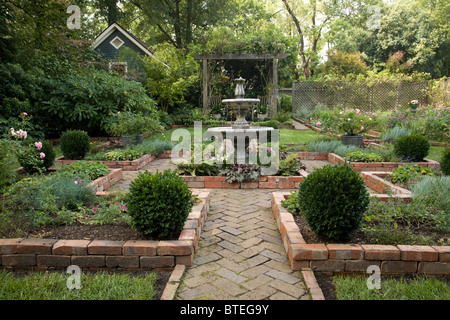 Mattone cortile con fontana e giardini. Foto Stock