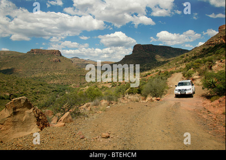 Un avvolgimento su strada sterrata con le colline in background Foto Stock