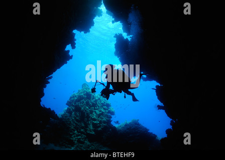 Scuba Diver nuoto in una grotta off Hamata costa, Egitto, Mar Rosso Foto Stock