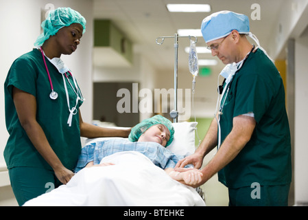 I lavoratori del settore sanitario il trattamento paziente in ospedale gurney Foto Stock
