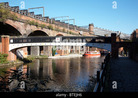A piedi ponte con tram e alla stazione viadotto sopra Bridgewater Canal in Castlefield Manchester REGNO UNITO Foto Stock