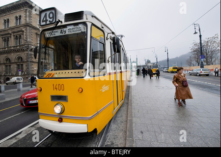 Shoppers croce una trafficata strada del tram vicino a Budapest il più grande mercato Nagycsarnok grande mercato, Ungheria Foto Stock