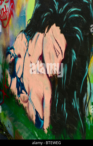 Graffiti / graffito che mostra un ritratto di una donna con lunghi capelli neri vestito vestito in un bikini top, Monaco di Baviera, Germania Foto Stock