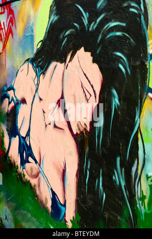 Graffiti / graffito che mostra un ritratto di una donna con lunghi capelli neri vestito vestito in un bikini top, Monaco di Baviera, Germania Foto Stock