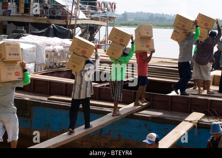 Operai cinesi sono il caricamento di una imbarcazione cargo con scatole di merci sul fiume Mekong in Chiang Sean, Thailandia. Foto Stock