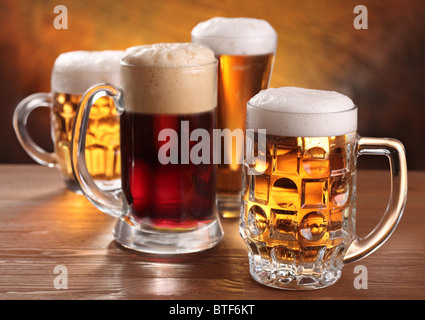 Cool boccali da birra su un tavolo di legno. Foto Stock