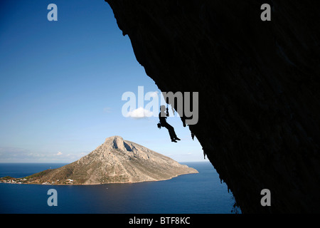 Arrampicata su roccia nella Grande Grotta Grotta con l'isola di Telendos in background, Kalymnos, Grecia, Foto Stock