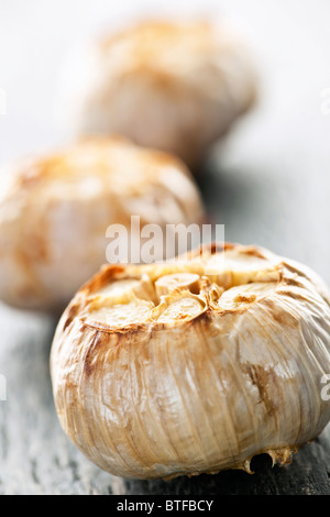 Close up di carni arrosto bulbi di aglio Foto Stock