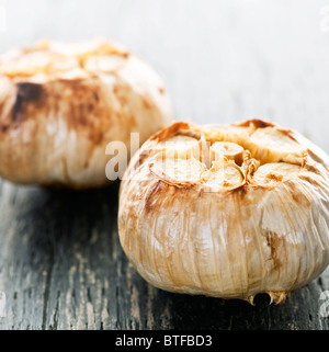 Close up di carni arrosto bulbi di aglio Foto Stock