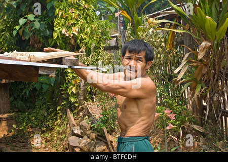 Local Thai man mano con bastone intagliato egli utilizza durante la raccolta del miele. Foto Stock