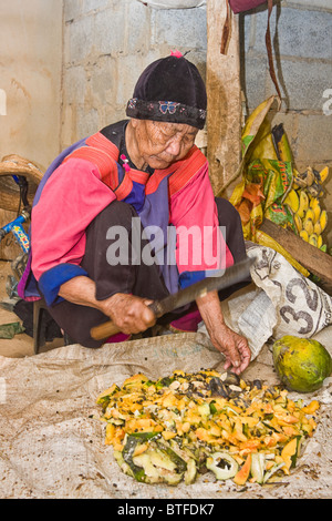 Vecchia donna, 86, indossando i vestiti tradizionali della tribù Lisu, costolette papaya in Lisu Village Chiang Mai nel nord della Thailandia. Foto Stock