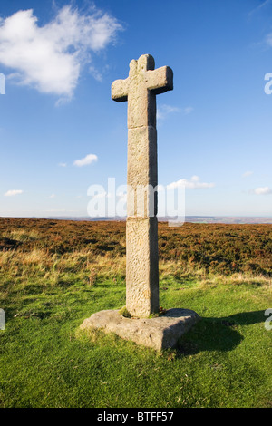 Giovani Ralph attraversare un crocifisso in pietra su Westerdale Moor nel North York Moors National Park North Yorkshire Regno Unito Foto Stock