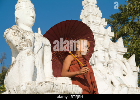 La Pagoda Settawya, giovane monaco buddista con un ombrello rosso scendendo le scale, Mingun, birmania, myanmar Foto Stock