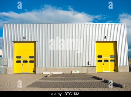 Magazzini industriali con due identici giallo porte a rullo Foto Stock
