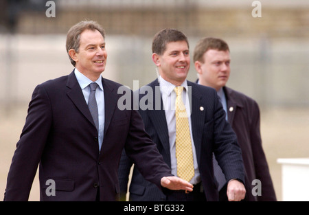 Il primo ministro Tony Blair accompagnato da due guardie del corpo sulla sfilata delle Guardie a Cavallo di salutare il Presidente della Repubblica Italiana Foto Stock