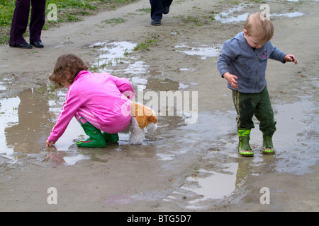 I bambini giocano in pozze di fango a Skagit Valley, Washington, Stati Uniti d'America. Foto Stock