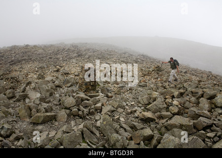 Un escursionista sulla sommità del Scafell Pike nel Parco Nazionale del Distretto dei Laghi. Foto Stock