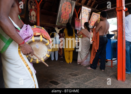 Un uomo giocando Thavil; un cilindro a forma di strumento a percussione- Kali Bhagavathy tempio di Kodungallur ; Kerala ; India . Foto Stock