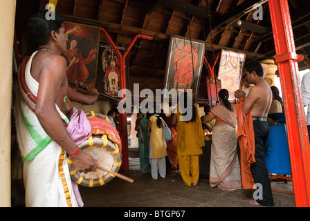 Un uomo giocando Thavil; un cilindro a forma di strumento a percussione- Kali Bhagavathy tempio di Kodungallur ; Kerala ; India . Foto Stock