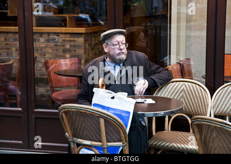 Ricerca intellettuale barbuto di mezza età uomo francese gustando un bicchiere di vino presso il cafe posti a sedere esterni Boulevard Saint Germain Foto Stock